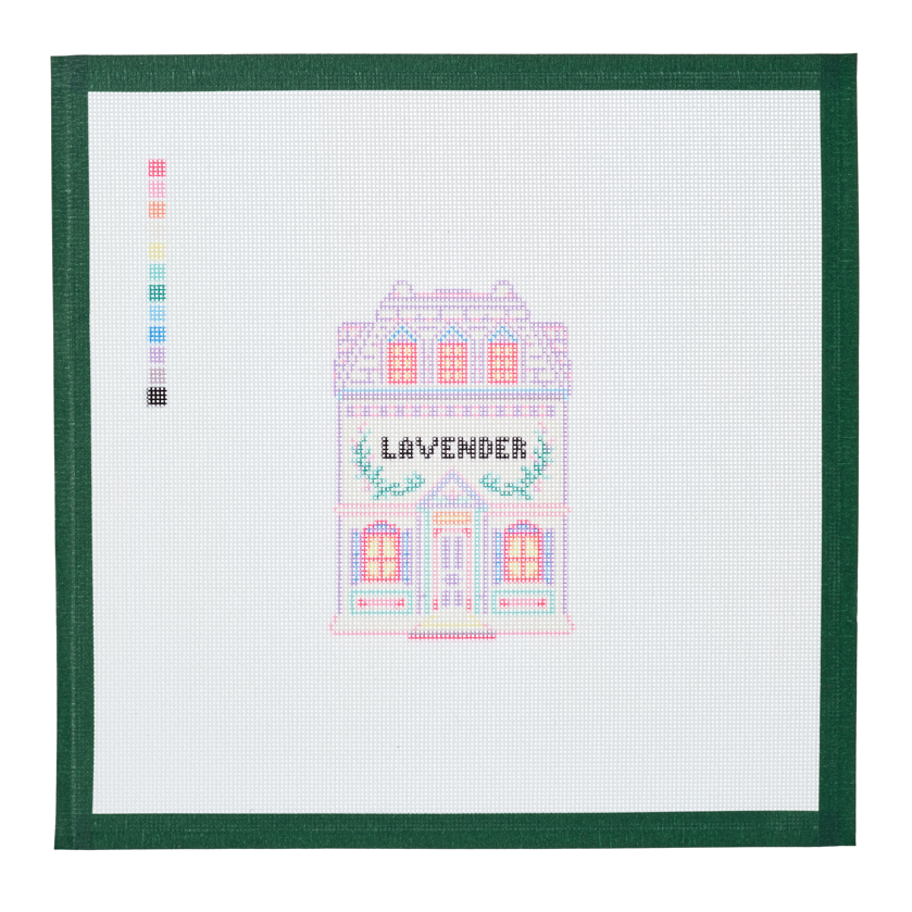 A needlepoint canvas of the Lavender house, a small pastel building with its name on the front, on white mesh with a green taped edge.